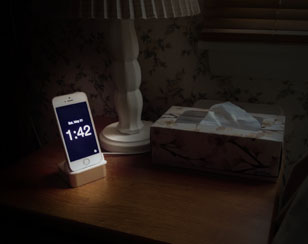 iPhone Disappearing Beside Clock on a night table
